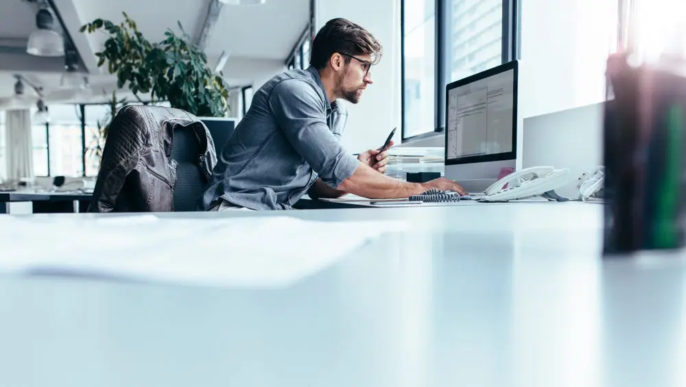Young,Man,Sitting,In,Office,And,Working,On,Desktop,Pc.