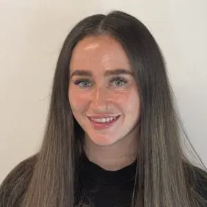 Elysia Martin smiling with long, dark, ombre hair and light-colored eyes.
