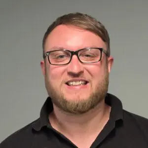 Martyn Shaw smiling wearing glasses and a black polo shirt