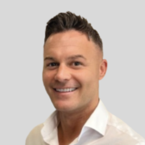 Gary Scouller smiling in a white collared shirt.